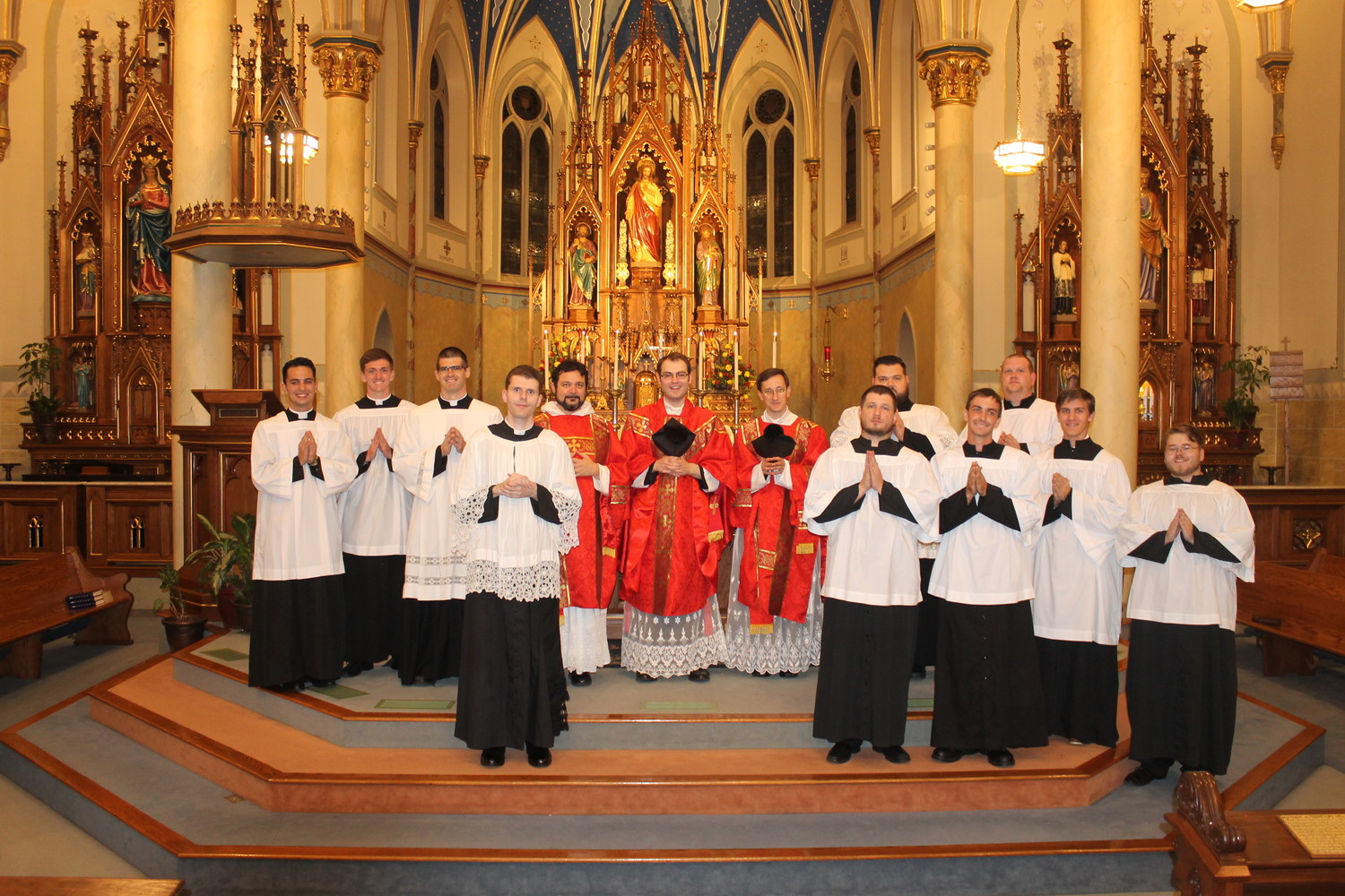 Father Dylan Schrader, center, gathers with the priests and altar servers who assisted him at Mass on Sept. 14 in St. Peter Church in Jefferson City.